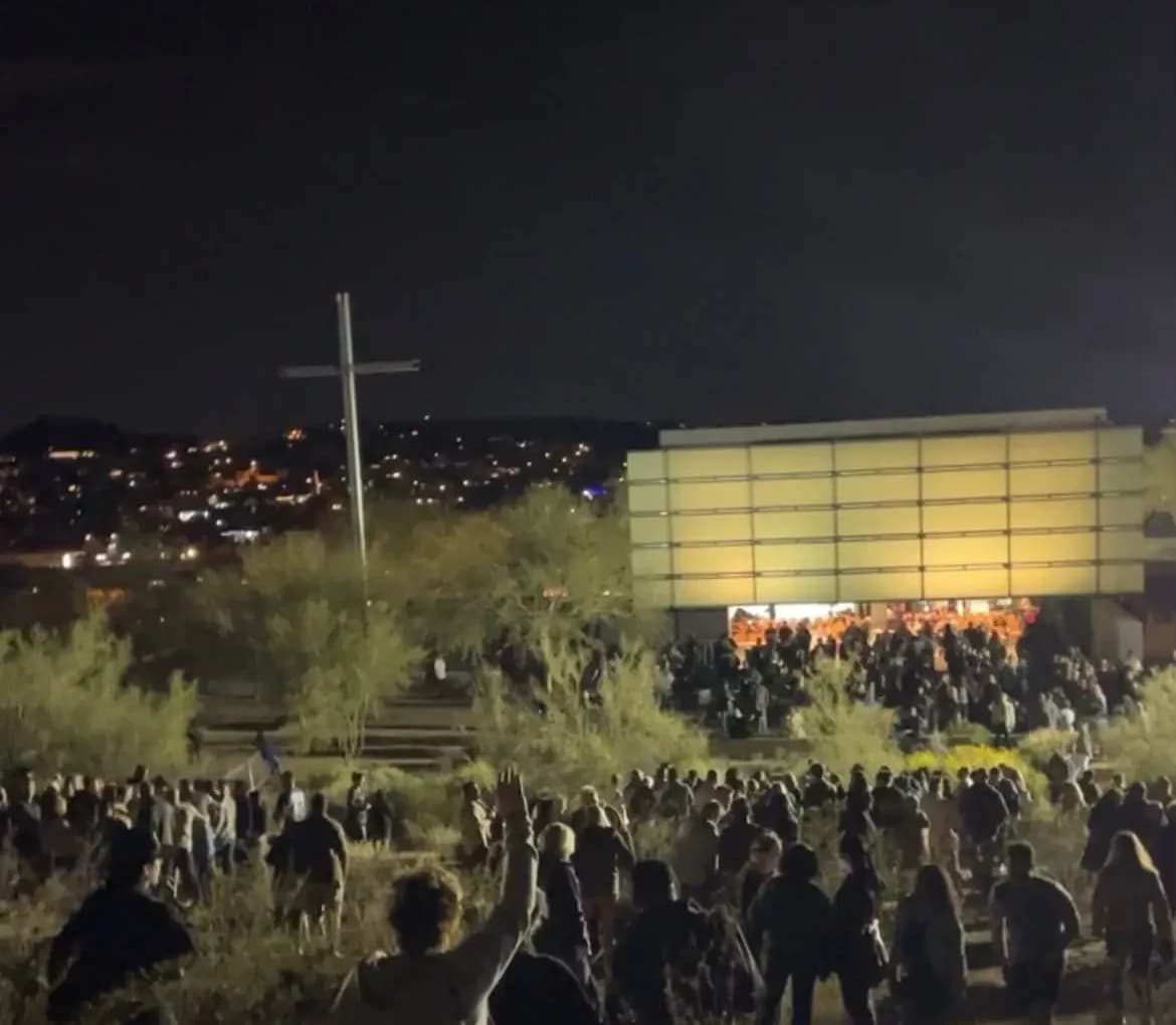 A crowd worshipping together with hands raised